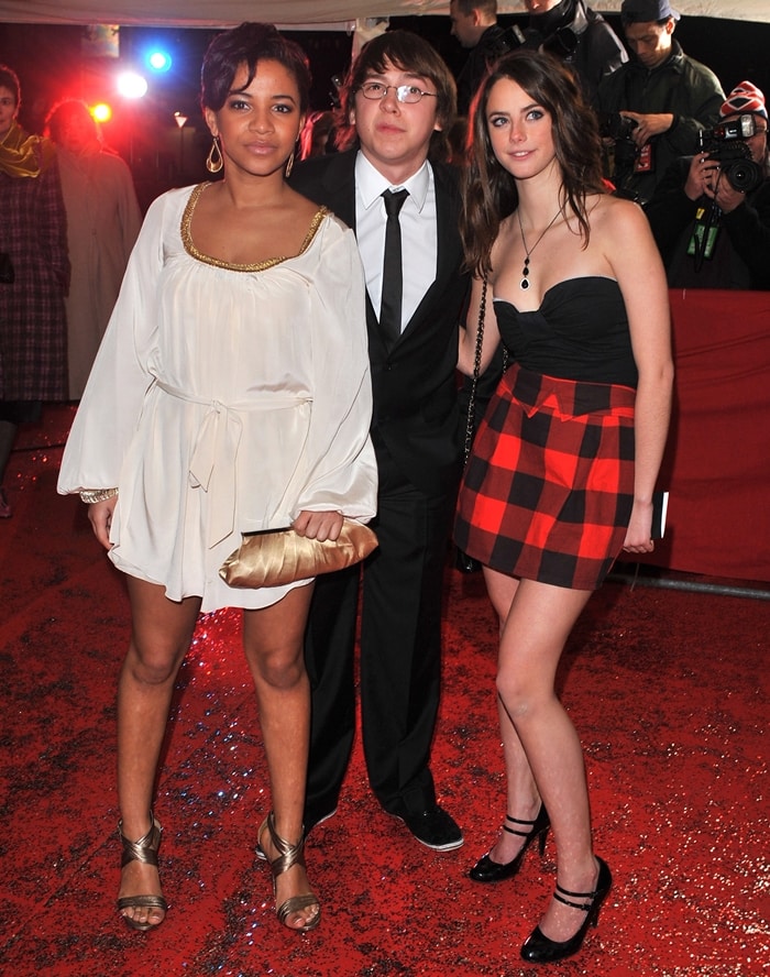 Kaya Scodelario steps out with her Skins co-stars Larissa Wilson and Mike Bailey at the 2008 British Comedy Awards, pairing a strapless black top and red plaid mini skirt with classic black ankle-strap heels for a youthful, red-carpet-ready finish