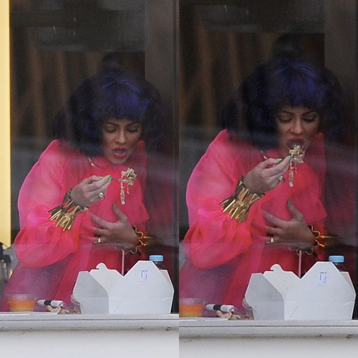 While wearing a blue wig and a sheer pink dress with gold cuffs, Kylie Jenner fuels up on takeout between her photoshoots