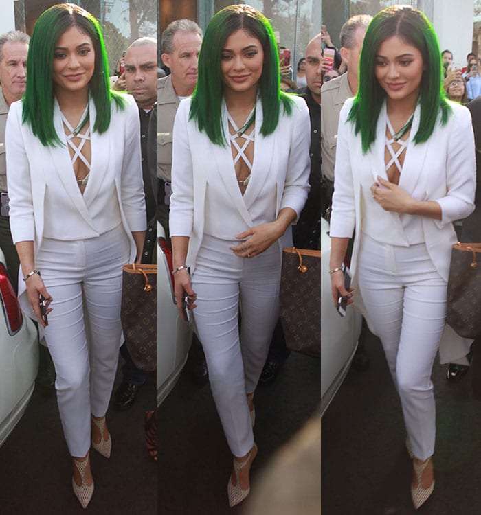Walking through a crowd, she balances sharp suiting with a soft glam finish, letting the transparent heels subtly elongate her frame