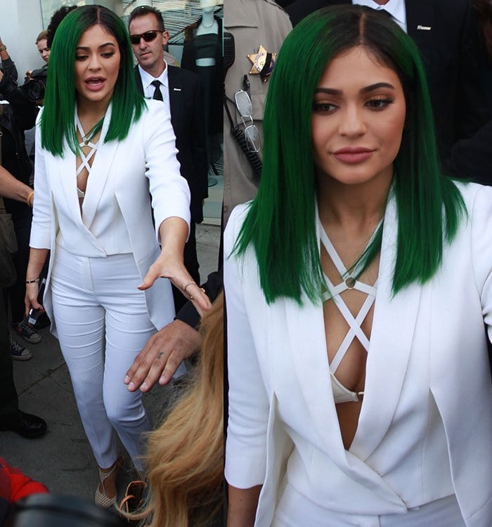 Stepping out to greet fans, Kylie’s crisscross lattice bra and sharp tailoring add edge to the clean monochrome palette