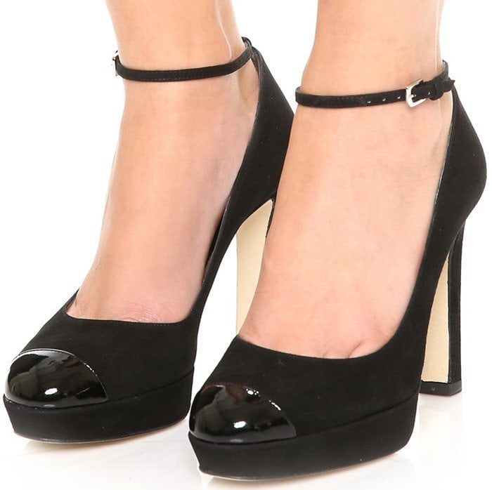 The L.K. Bennett “Sally” platform pumps pair plush black suede with a glossy patent cap toe, while the slim stiletto and subtle platform work together to deliver height, balance, and a quietly polished finish