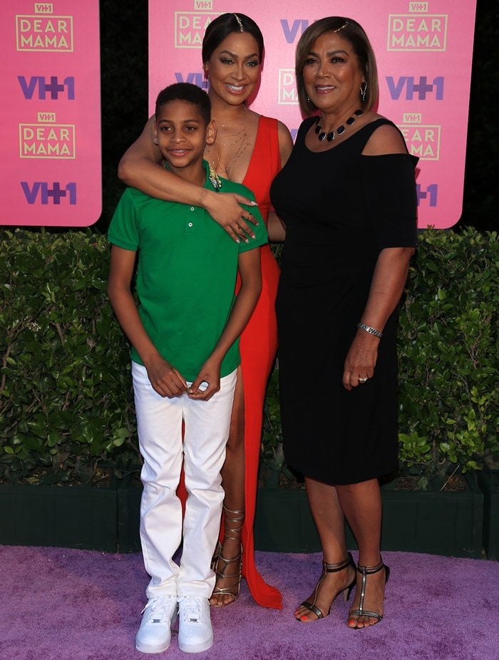 La La Anthony arrives at VH1’s 2nd Annual Dear Mama event in Pasadena wearing a sleek red Zachary the Label gown and gold strappy sandals, joined by her son Kiyan and her mother, Carmen Surillo