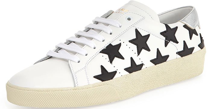 Saint Laurent’s white Court Classic SL/06 sneakers feature bold black leather star appliqués and a creamy, lightly distressed rubber sole that channels the brand’s signature grunge-luxe attitude
