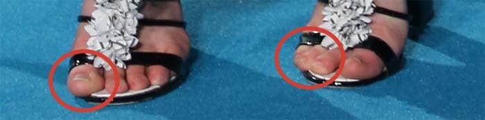 A close-up reveals a slight toe overhang at the front of the sandals, a common fit issue with narrow, strappy evening heels