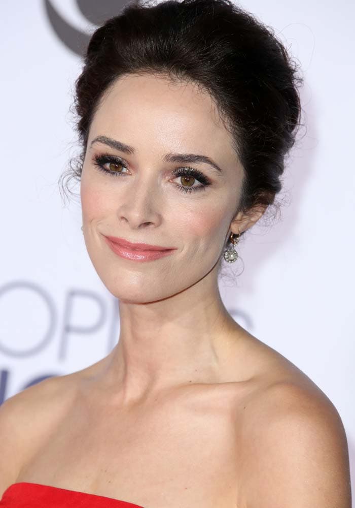 Abigail Spencer wears a softly textured updo, luminous makeup, and delicate drop earrings at the People’s Choice Awards