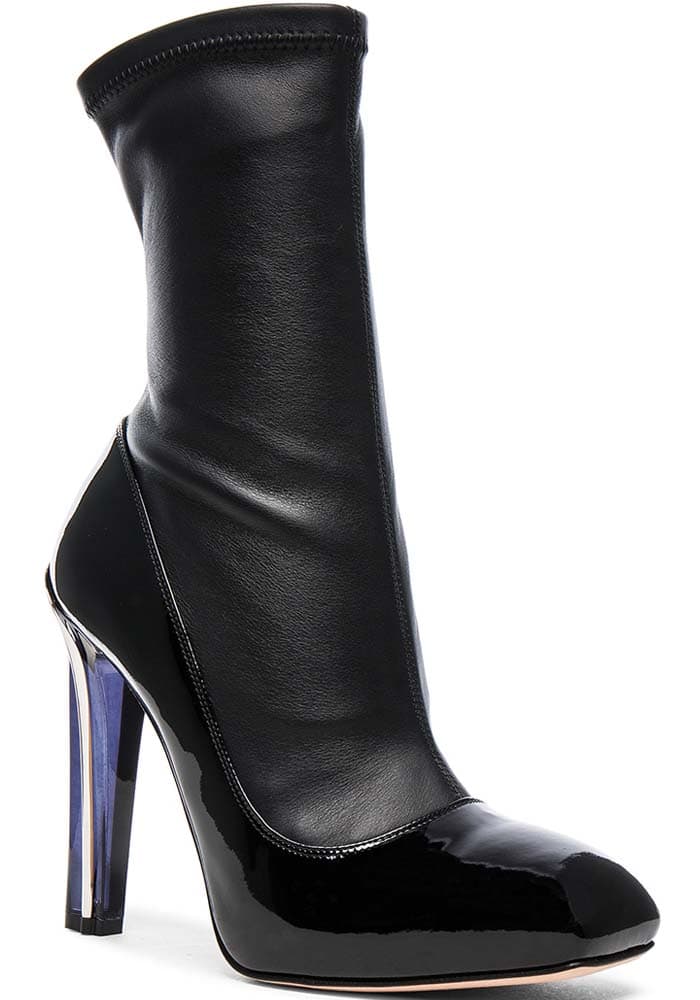 The black patent version emphasized the boot’s sharper architectural lines, contrasting a stretch sock shaft with a high-shine lacquered base and a dramatic plexi-effect heel.