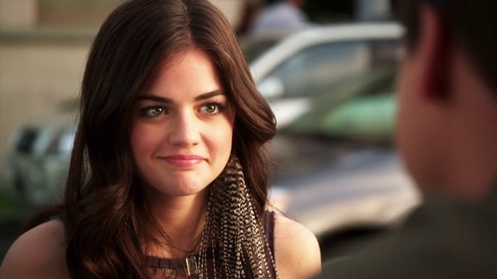 Lucy Hale, age 20, appears in her debut as Aria Montgomery in the 2010 premiere of Pretty Little Liars, sporting long brunette curls and signature feather hair extensions