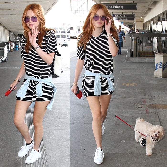 Bella Thorne keeps airport style playful and relaxed, pairing a striped mini dress with fresh white sneakers while departing Los Angeles International Airport (LAX) with her dog on September 11, 2015