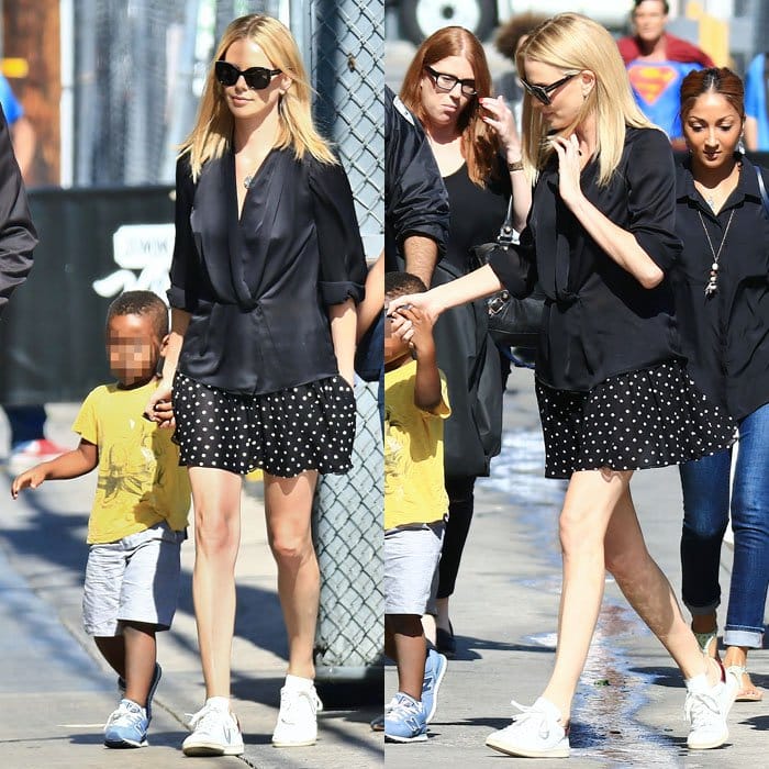 Charlize Theron demonstrates the enduring appeal of high–low styling, pairing a fluid satin blouse and skirt with clean white sneakers