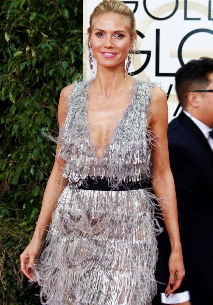 Heidi Klum balances texture and silhouette at the Golden Globes, pairing flapper-inspired fringe with barely-there metallic heels for a streamlined finish