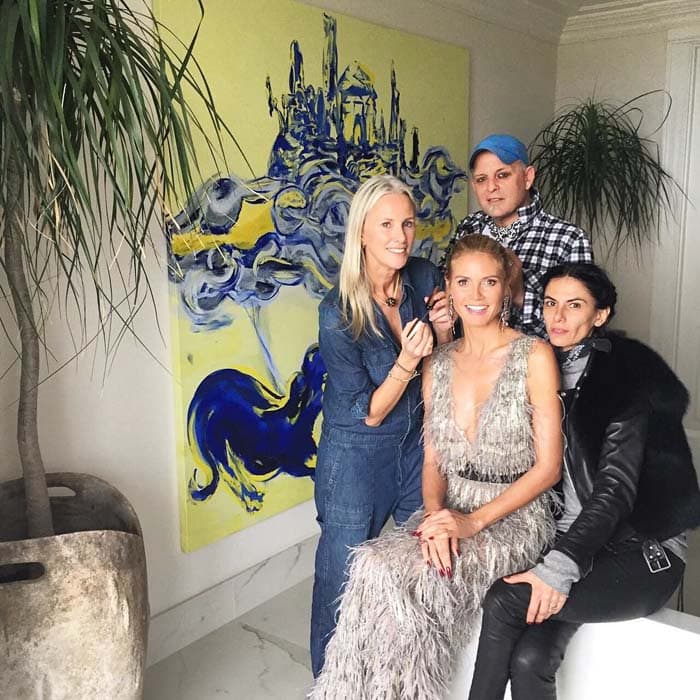 Behind the scenes, Heidi Klum poses with her glam team, offering a candid glimpse of the intricate fringe detailing that defines her red carpet look