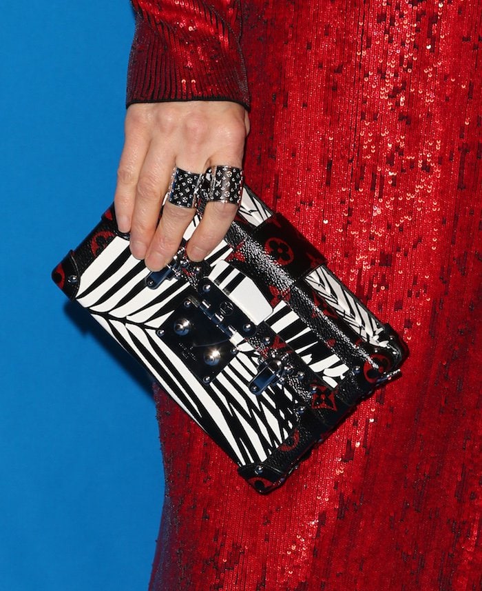 Jennifer Connelly completes her Louis Vuitton ensemble with a bold, striped clutch and matching statement rings