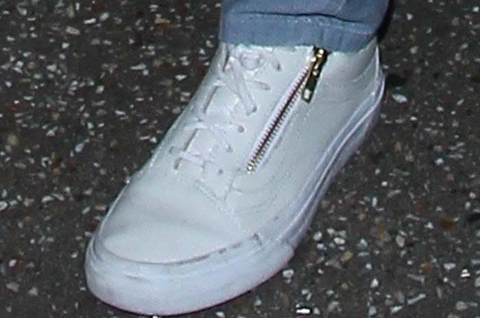 Close-up of Jessica Alba’s sneakers, featuring a sleek, white design with a zipper detail, adding a modern touch to her laid-back airport outfit
