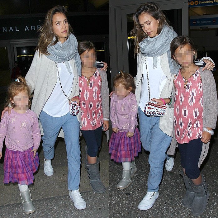 Jessica Alba keeps airport style practical yet polished, grounding her soft layered travel look with crisp white sneakers while arriving at Los Angeles International Airport (LAX) with her daughters on January 2, 2016