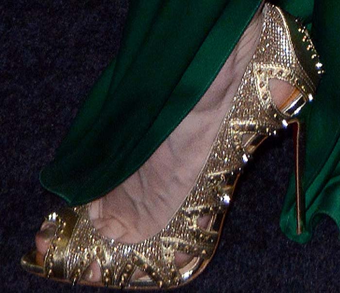 Jessica Chastain stepped out in gold Christian Louboutin “Pinder City” pumps, a peep-toe design with cutout details, pyramid studs, and the brand’s signature red sole adding a striking finish to her look
