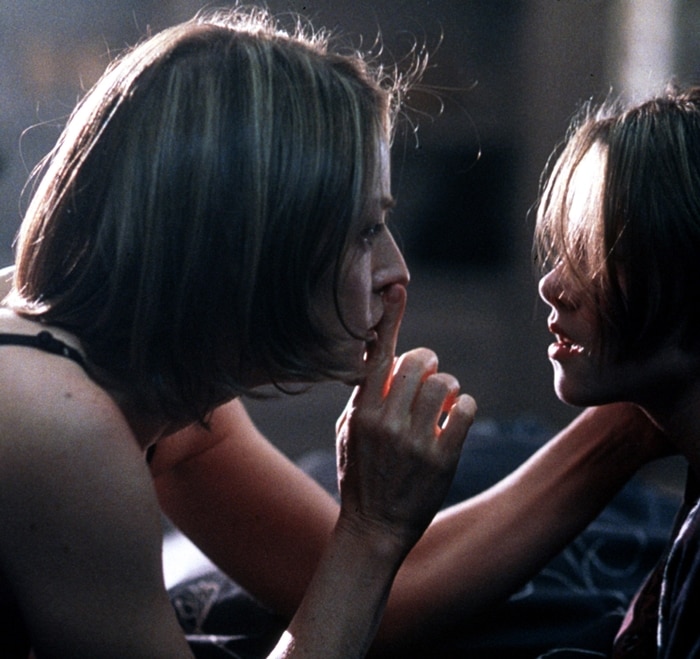 Jodie Foster's character signals Kristen Stewart to stay quiet in a suspenseful scene from Panic Room