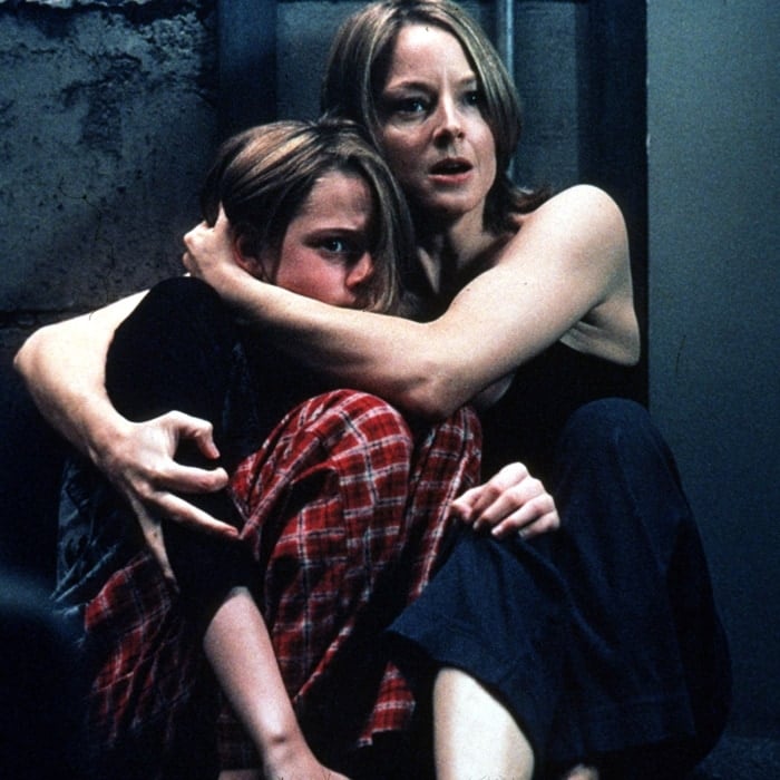 Jodie Foster tightly embraces Kristen Stewart in a suspense-filled scene from David Fincher’s 2002 thriller Panic Room, capturing the film’s claustrophobic tension