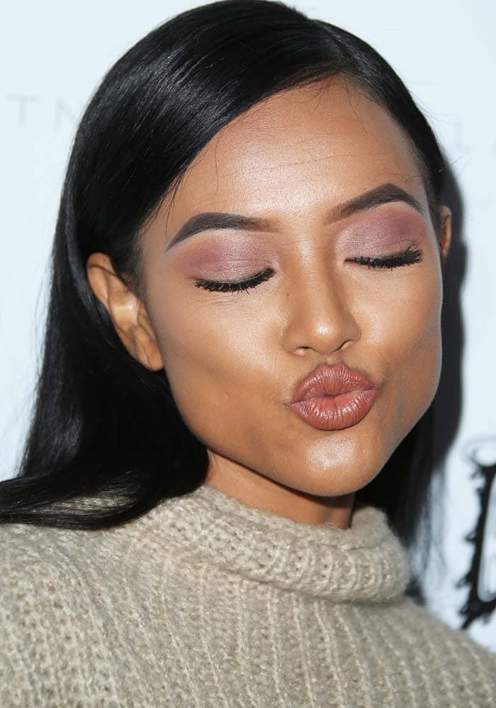 Karrueche Tran paired soft mauve eye shadow and fluttery lashes with a nude glossy lip, keeping the beauty look tonal and understated against her monochromatic outfit