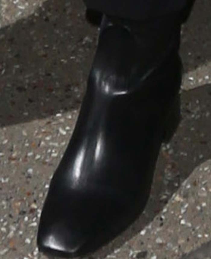 Close-up of Kendall Jenner’s black leather Sandro “Amele” ankle boots featuring a squared toe and low stacked heel — a minimalist staple from the French label