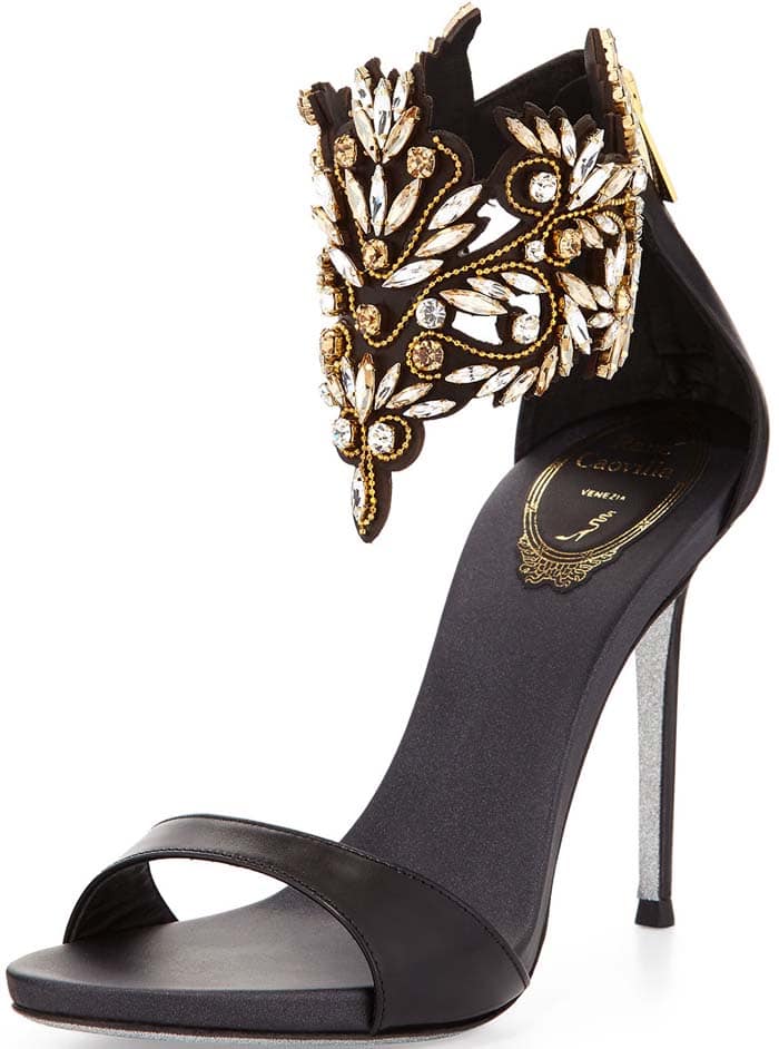René Caovilla’s black Embellished Ankle Cuff Sandal features an elaborate jeweled cuff, slim stiletto heel, and understated single front strap; the style originally retailed for $1,800