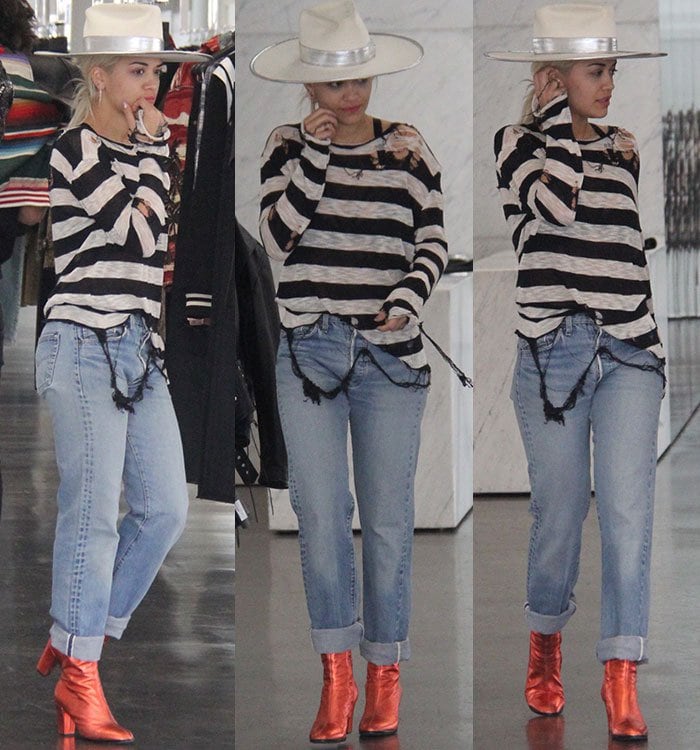 Rita Ora wears a pair of iridescent red boots with her cuffed denim jeans