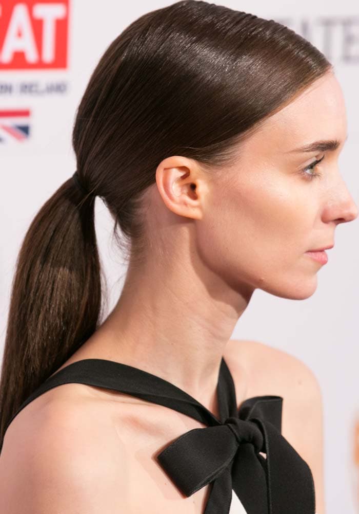 Rooney Mara completes her BAFTA Los Angeles Awards Season Tea look with sleek, side-parted hair pulled into a low ponytail