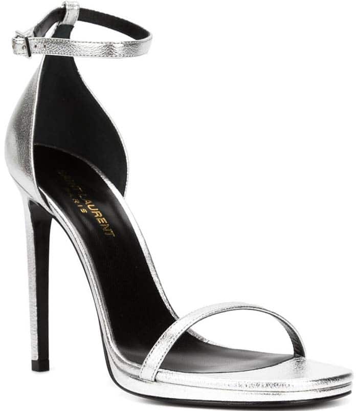 Saint Laurent’s silver “Jane” sandals feature a sleek two-strap silhouette and needle-thin stiletto heel, making them a modern icon of Parisian minimalist footwear