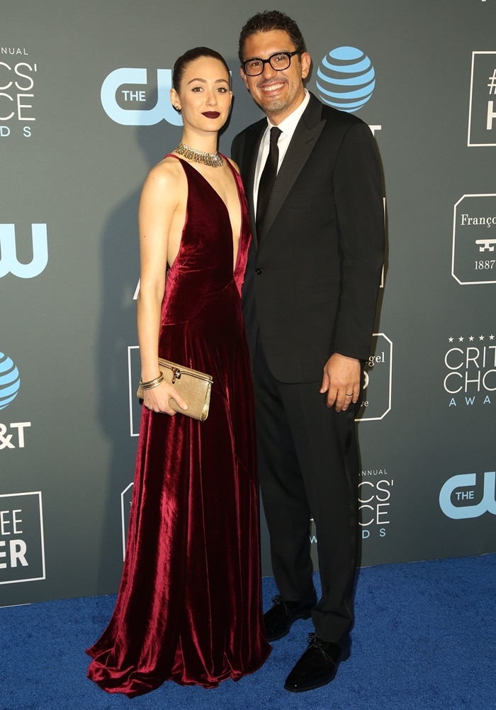 Emmy Rossum offset the couple’s noticeable height difference in sky-high Christian Louboutin heels, the leg-lengthening stilettos subtly elevating her burgundy Ralph Lauren velvet gown to bring her closer in stature to husband Sam Esmail at the 24th annual Critics’ Choice Awards in Santa Monica