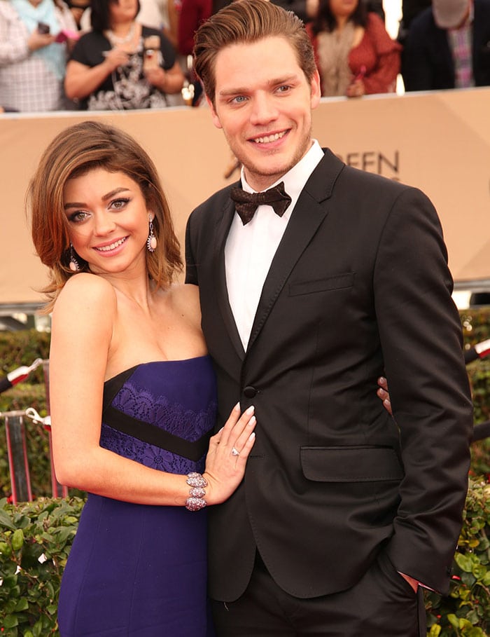Sarah Hyland arrives with then-boyfriend Dominic Sherwood, complementing her elegant J. Mendel gown with Lorraine Schwartz and Ofira jewelry while Sherwood opts for a classic black tuxedo