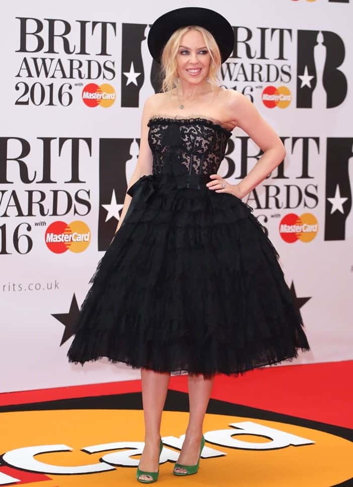 Kylie Minogue embraced playful vintage glamour at the 2016 Brit Awards in a strapless black lace Dolce Gabbana dress, adding a pop of color with bold green satin peep-toe pumps that perfectly offset her voluminous tulle skirt