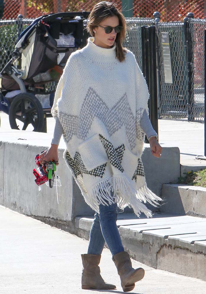 Alessandra Ambrosio effortlessly styled her cozy Elizabeth James poncho with a fitted gray knit sweater, skinny jeans, and Isabel Marant "Crisi" boots, creating a chic yet relaxed off-duty look