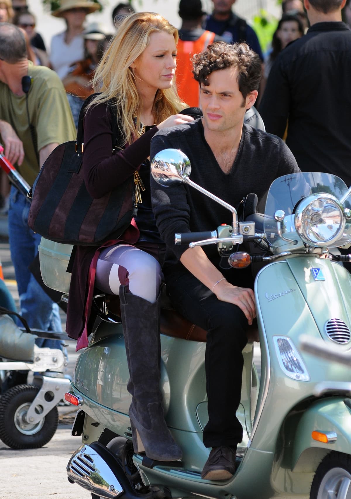 Blake Lively, wearing knee-high suede heeled boots and carrying a striped suede handbag, rides a mint-green Vespa scooter with Penn Badgley while filming Gossip Girl in Central Park, New York City, on August 28, 2012