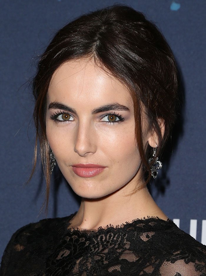Camilla Belle styles her hair in a soft, center-parted updo with face-framing tendrils