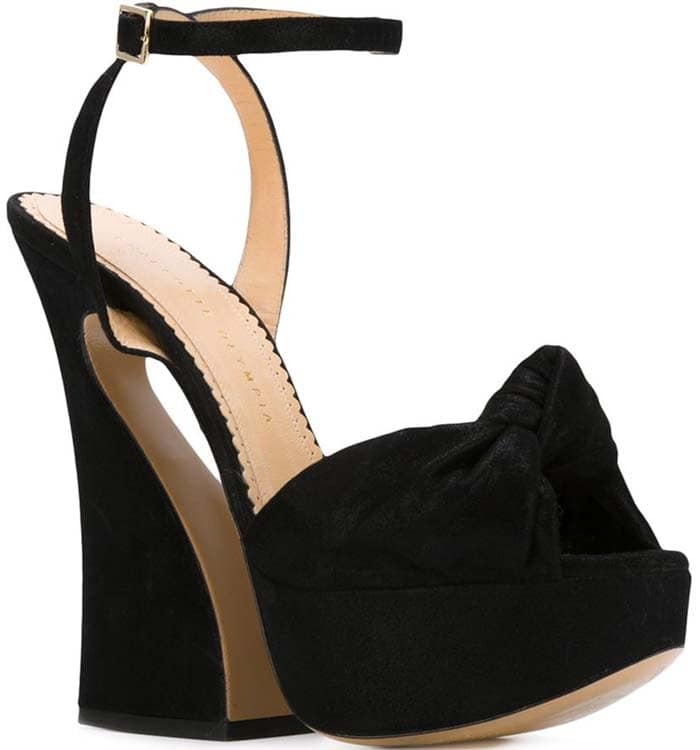 Charlotte Olympia “Vreeland” black suede platform sandals with a dramatic knotted bow and towering sculptural heel that channels retro-inspired glamour