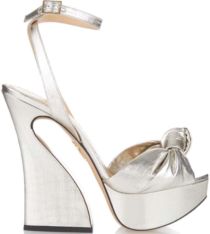 Charlotte Olympia “Vreeland” metallic lamé platform sandals featuring the brand’s signature sculptural curved heel and oversized knotted bow