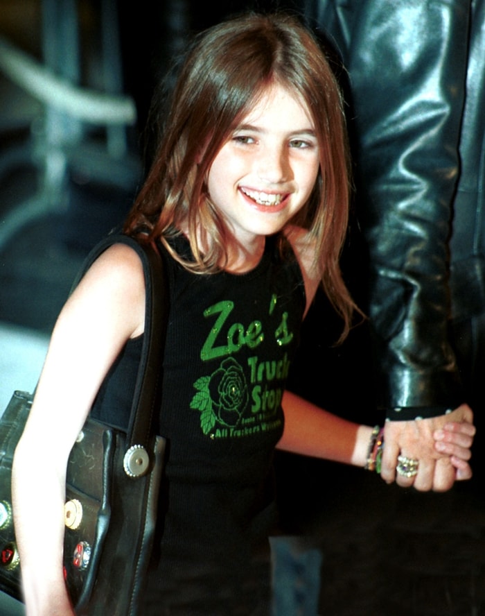 10-year-old Emma Roberts wearing a sleeveless black Zoe’s Truck Stop top paired with a studded shoulder bag