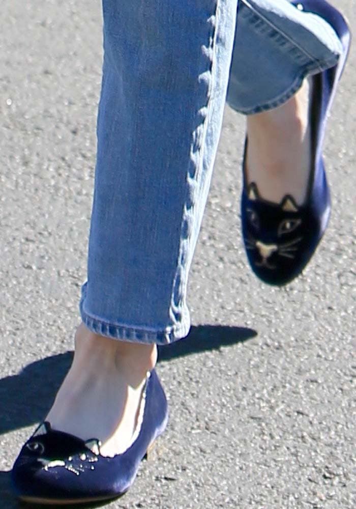 Emma Roberts steps out in blue velvet Charlotte Olympia “Kitty” flats, the brand’s signature slipper featuring an embroidered cat face and low gold heel, paired with casual cropped denim jeans