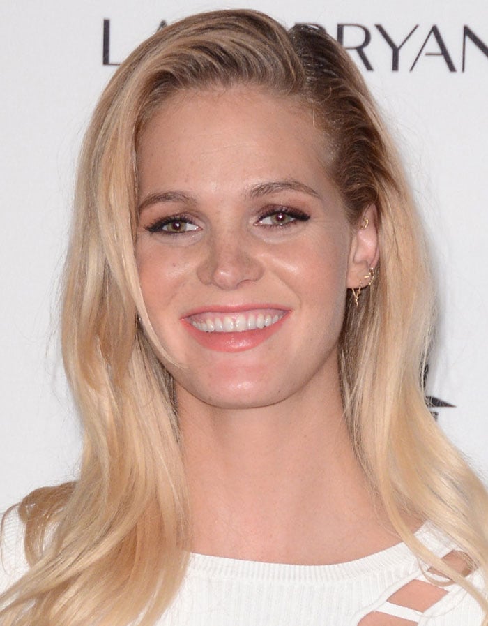 Erin Heatherton completes her look with subtle gold earrings, complementing her natural makeup and waved blonde hair