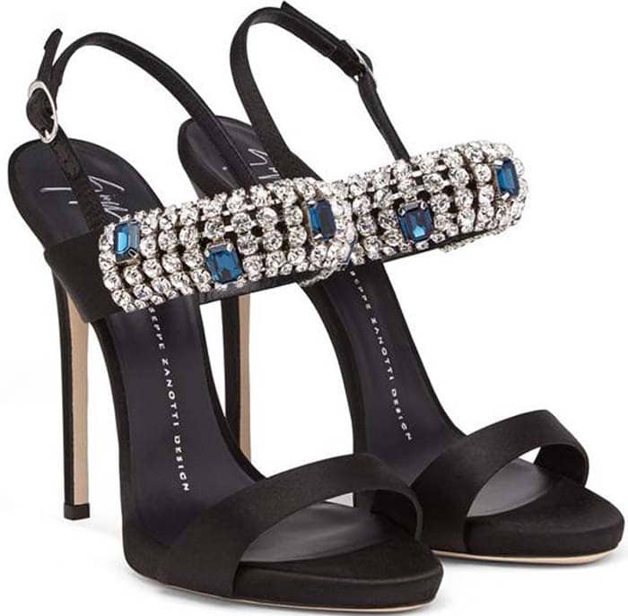 Giuseppe Zanotti "Carine" sandals feature slender stiletto heels, black satin straps, and crystal-covered front bands accented with blue stones