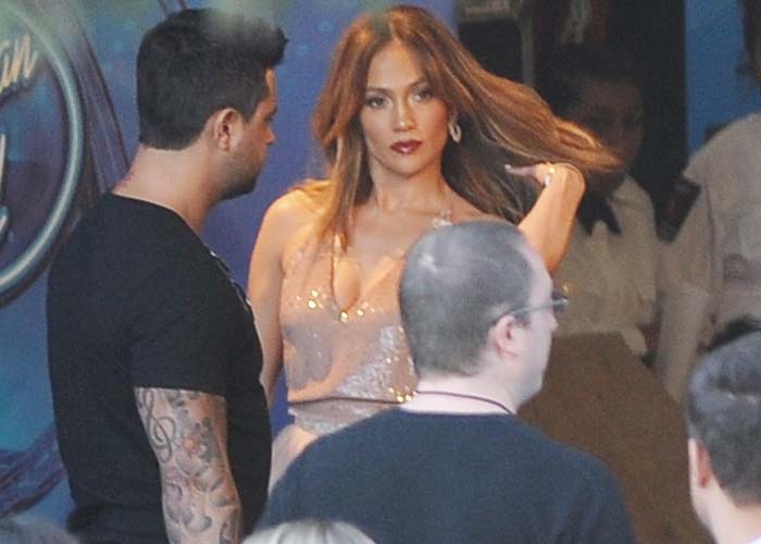 Jennifer Lopez's softly waved, caramel-highlighted hair and luminous makeup echoed the blush tones of her Valentino dress, creating a cohesive monochromatic red-carpet look