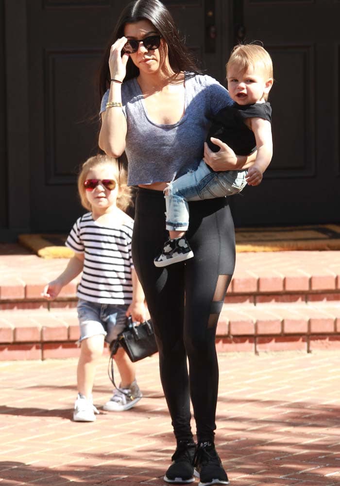 Kourtney Kardashian steps out in sleek mesh-panel Beyond Yoga leggings and black APL Ascend sneakers, effortlessly balancing mom duties with athleisure style
