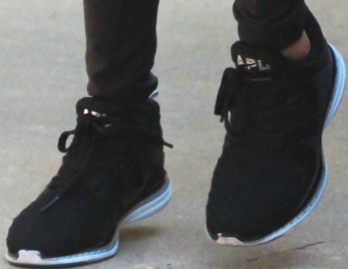 Kourtney Kardashian hits the trail in a pair of black APL Ascend sneakers, featuring a breathable knit upper and cushioned sole designed for high-performance comfort