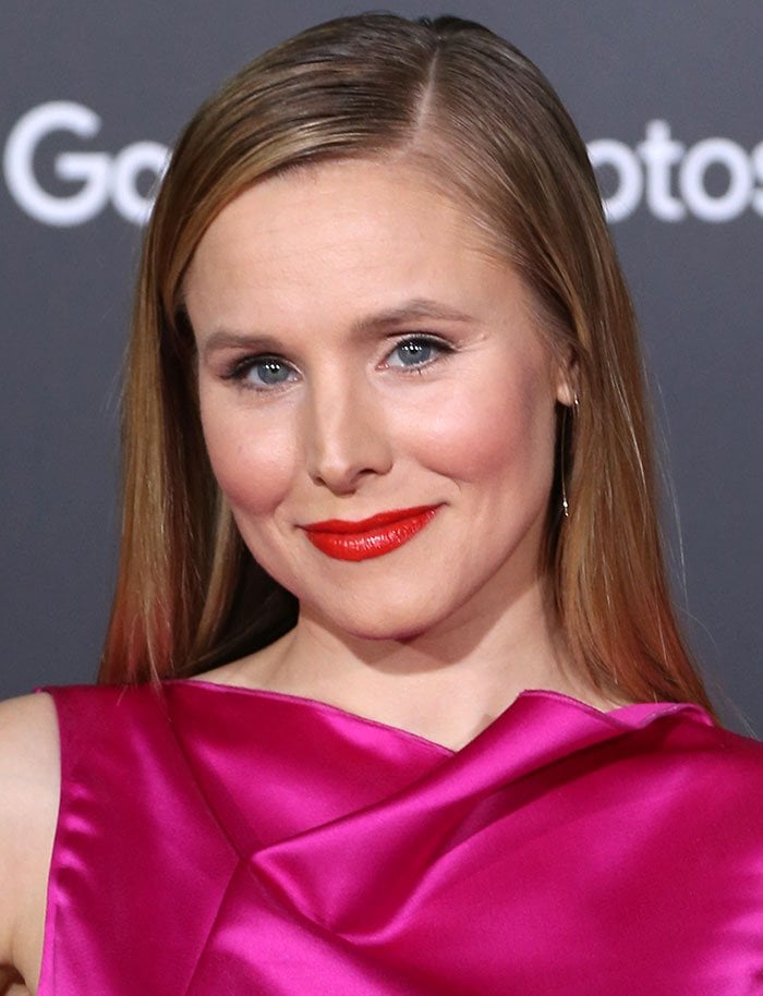 Kristen Bell stuns in a vibrant fuchsia gown, perfectly complemented by bold red lips