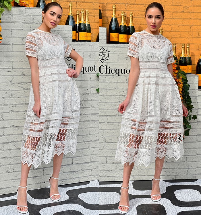Posing against a champagne-lined backdrop, Olivia Culpo highlights the intricate texture and airy movement of her fit-and-flare lace dress