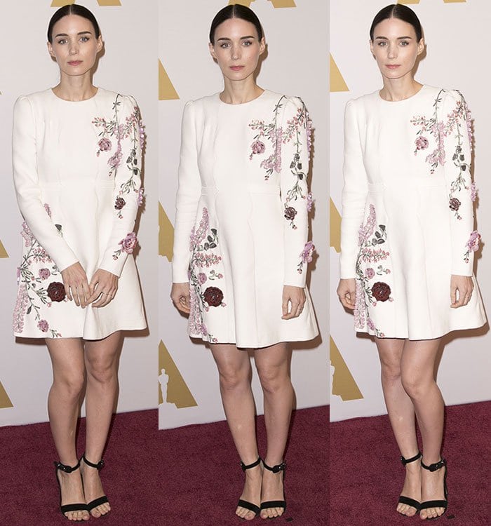 Rooney Mara kept the look crisp and feminine, grounding her embroidered white Giambattista Valli mini dress with classic black ankle-strap sandals that added quiet structure to the soft floral detailing
