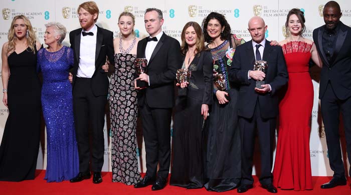 Kate Winslet, Julie Walters, Domhnall Gleeson, Saoirse Ronan, John Crowley, Finola Dwyer, Amanda Posey, Nick Hornby, a guest, and Idris Elba celebrate with the Outstanding British Film award for Brooklyn in the winners’ room at the EE British Academy Film Awards, held at the Royal Opera House on February 14, 2016, in London, England