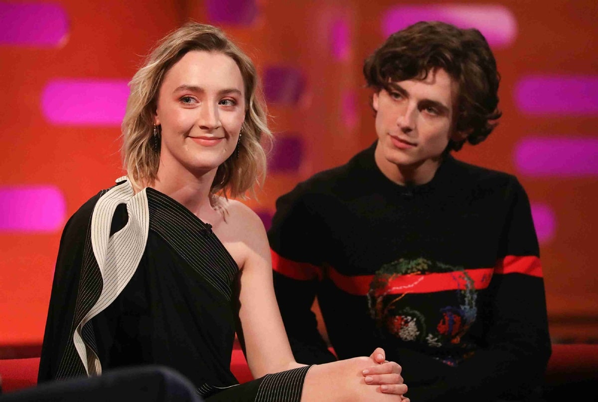 Saoirse Ronan looked sleek in a one-shoulder black dress with sculptural white detailing, while Timothée Chalamet kept it casual in a black sweater with bold red stripes during their joint TV appearance