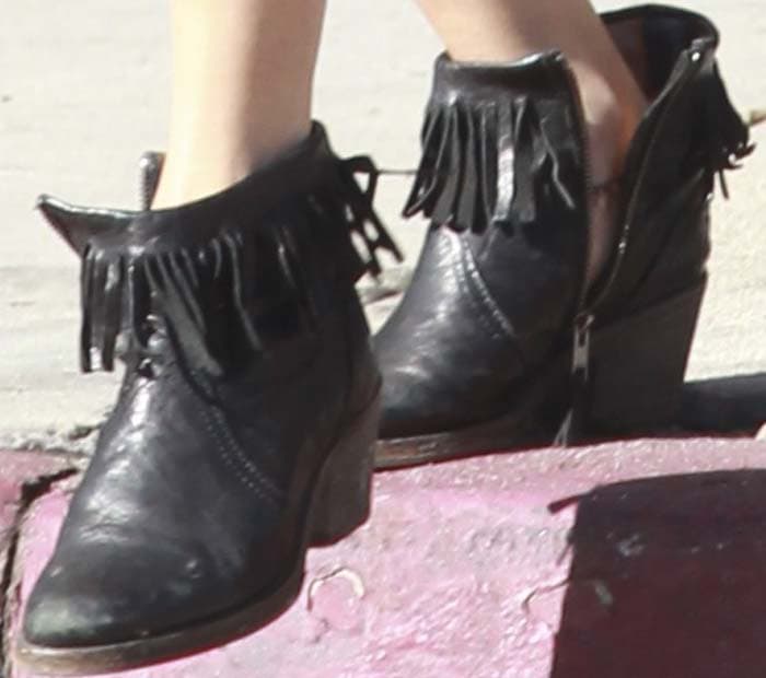 Vanessa Hudgens completes her boho-inspired look with black leather ankle boots featuring playful fringe detailing and a sturdy block heel