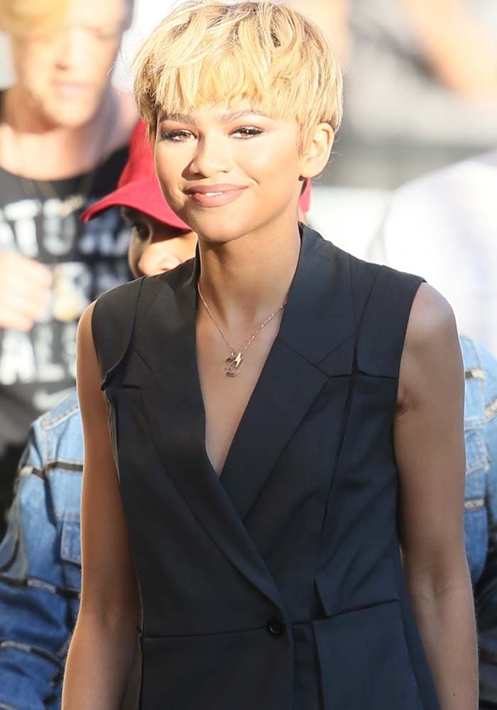 Zendaya complements her sleek sleeveless double-breasted vest with a cropped blonde wig and delicate necklace