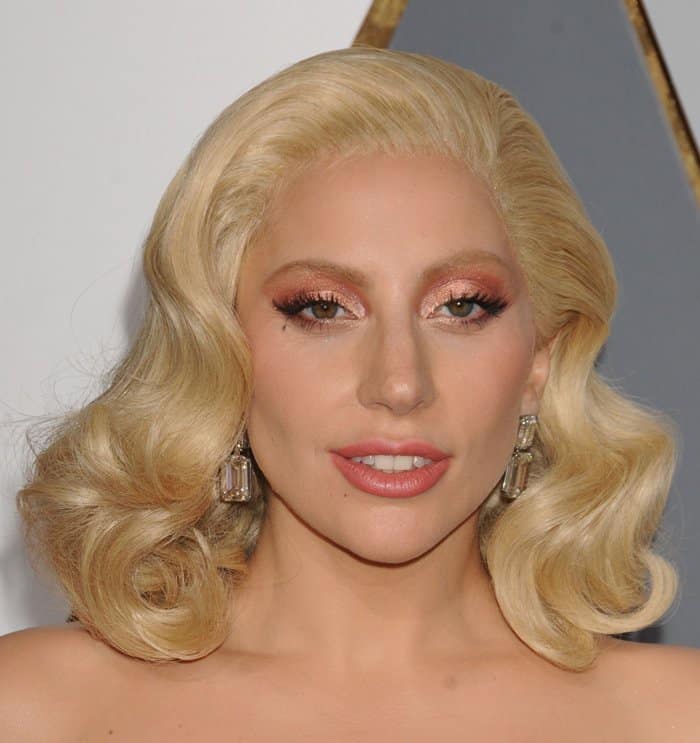 Lady Gaga highlights her $8 million Lorraine Schwartz teardrop diamond earrings with Old Hollywood waves and soft rose-gold eye makeup at the 2016 Oscars